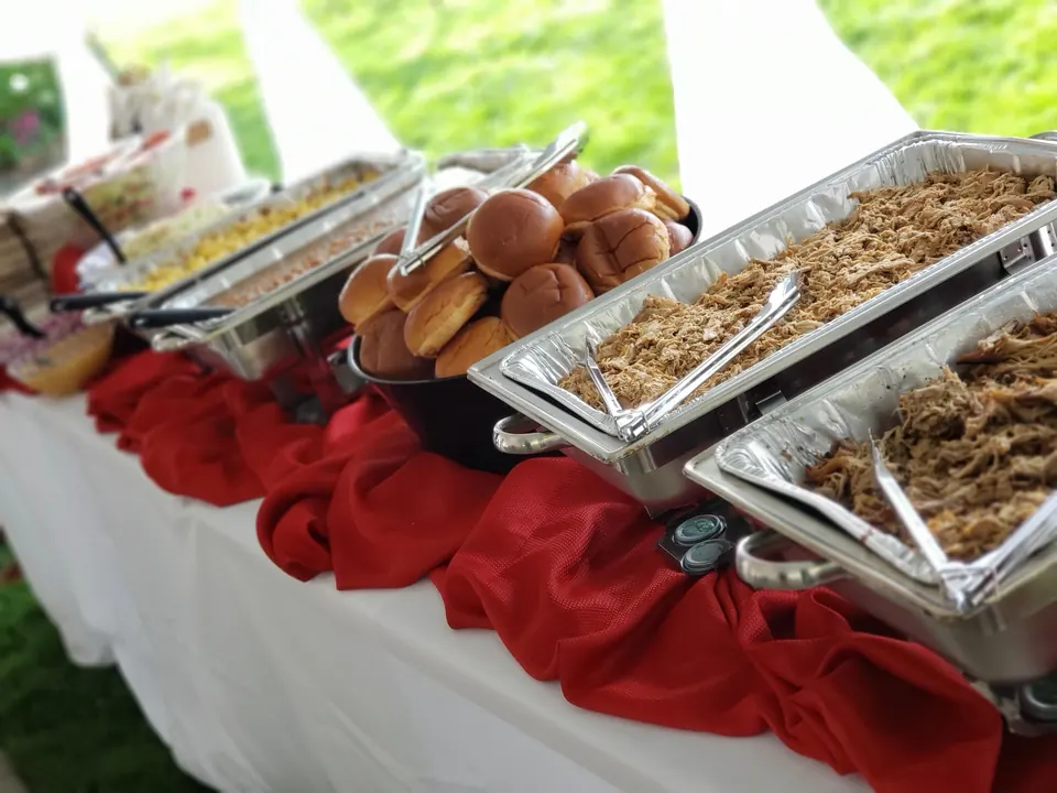 Iron Pig catering buffet line with chafing dishes of smoked meats and sides